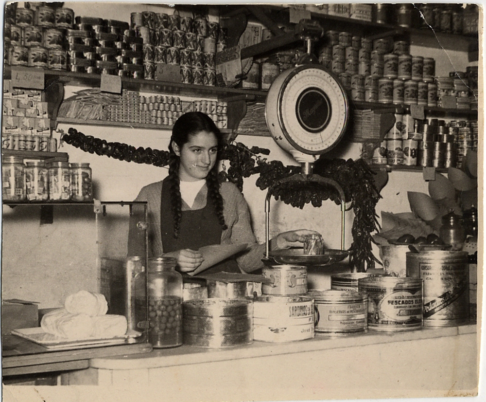 Una joven dependienta en la tienda de ultramarinos