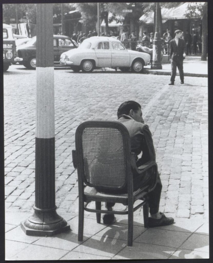 Miniatura de Hombre sentado en una silla en la acera